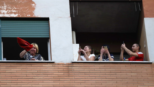 People stand at the window of their apartments during one of the many flash mobs taking place these days in Rome. 