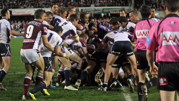 Manly and Melbourne players go at it on the halfway line at Brookvale.