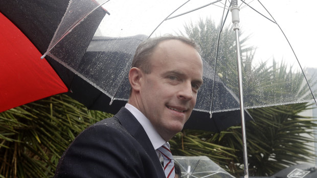 Britain's Foreign Secretary Dominic Raab shelters from the rain in Sydney, in February, at a visit to the British-Swedish multinational biopharmaceutical company, AstraZeneca.