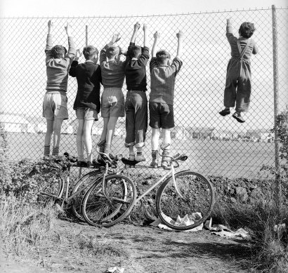 Children climbing up the wire fence at the Melbourne Olympic Village on 21 November, 1956.