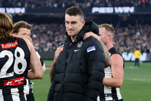 Dan McStay is consoled by teammates after Collingwood’s preliminary final victory.