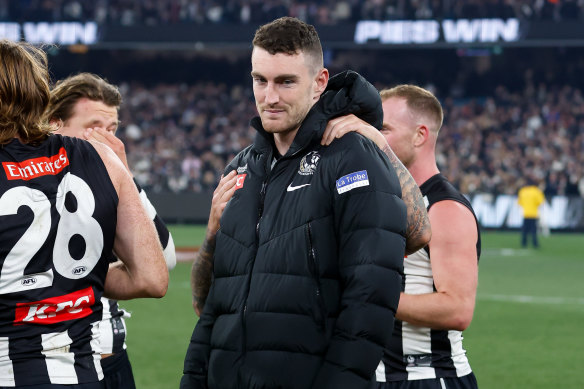 Dan McStay is consoled by teammates after Collingwood’s preliminary final victory.