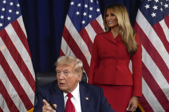 Right behind him: As Melania Trump watches, Republican presidential candidate Donald Trump signs paperwork to officially accept the nomination to run for president again this year.