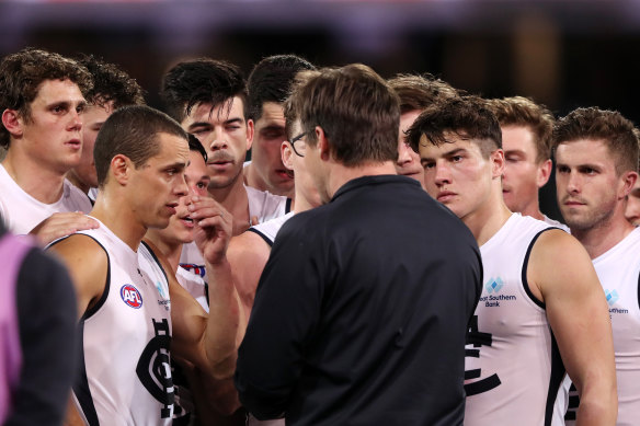 Uncertain futures: Carlton players listen to coach David Teague during round 22. 