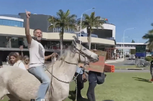 Protesters, including a horseback-riding Michael Corrigan, along the NSW-Queensland border in Coolangatta last Sunday.