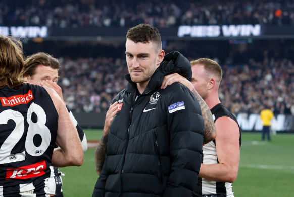 Dan McStay is consoled by teammates after Collingwood’s preliminary final victory.