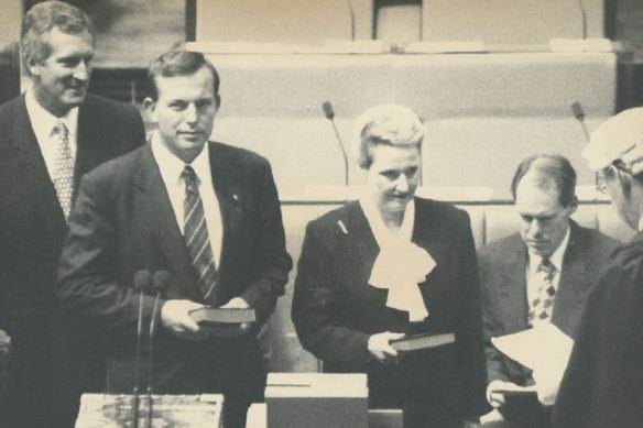 In 1994, former Liberal leader John Hewson watches on as Tony Abbott and Bronwyn Bishop are sworn in.