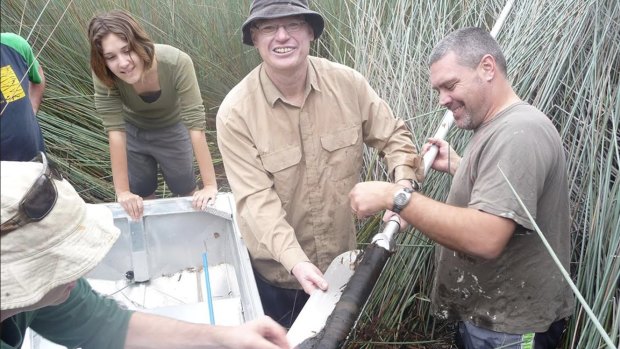Researchers John Tibby, Lydia McKenzie, Jonathan Marshall and Cameron Barr take core samples from Duck Lagoon, North Stradbroke Island.