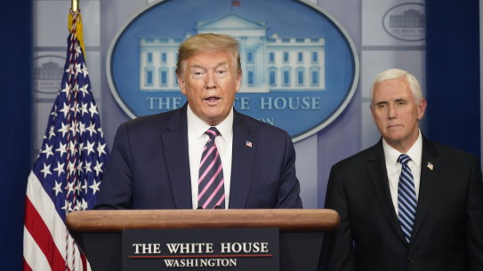 Donald Trump speaks as Vice-President Mike Pence looks on. The White House is moving against the WHO on several fronts.