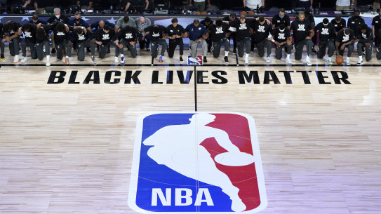 Members of the New Orleans Pelicans and Utah Jazz kneel together before the resumption of the NBA season in Florida.
