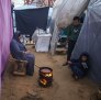 Displaced Palestinians cook food in a temporary shelter at a camp in Gaza.