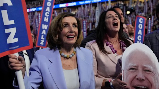 Representative Nancy Pelosi holds a sign during the Democratic National Convention.