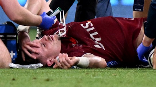 Reds player Isaac Henry (C) receives treatment for an injury during the Super Rugby match between the Melbourne Rebels and the Queensland Reds in Melbourne on March 15, 2024. (Photo by William WEST / AFP) 