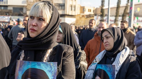 Women hold posters as thousands of people gather in Enghelab Square, Tehran, after Iranian state media confirmed the death of Ayatollah Ali Khamenei.