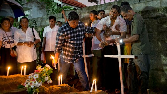 Relatives place flowers after the burial of three victims of the same family, who died at Easter Sunday bomb blast at St Sebastian Church in Negombo, Sri Lanka.