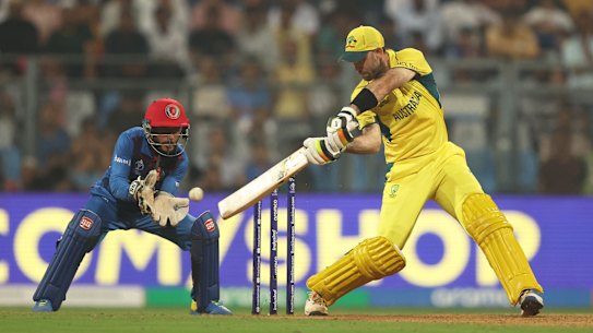 Glenn Maxwell of Australia plays a shot as Ikram Alikhil of Afghanistan keeps.