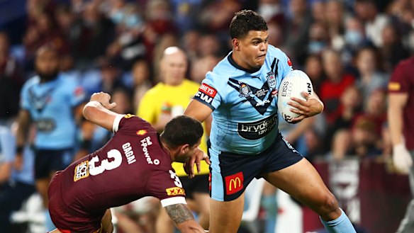 Latrell Mitchell puts a fend on Dane Gagai.