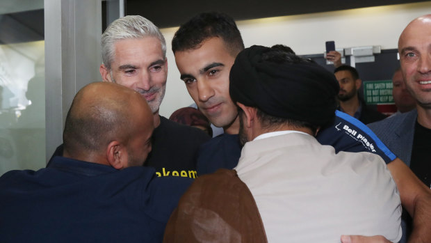 Former Socceroo Craig Foster (left) is seen with refugee footballer Hakeem Al-Araibi (centre) as he is greeted by supporters upon arriving at Melbourne International Airport in Melbourne, Tuesday, February 12, 2019.