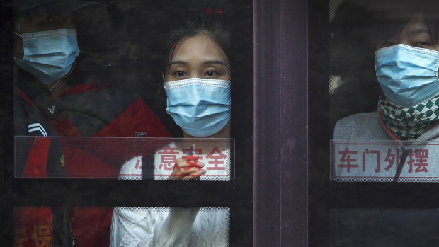 Commuters look out from a bus in Beijing on Monday. Schools and kindergartens have been suspended and communities are on lockdown in Kashgar, a city in China's northwest Xinjiang region after a spate of cases.