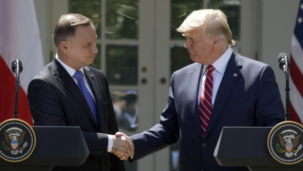 President Donald Trump shakes hands with Polish President Andrzej Duda during a news conference in the Rose Garden of the White House.