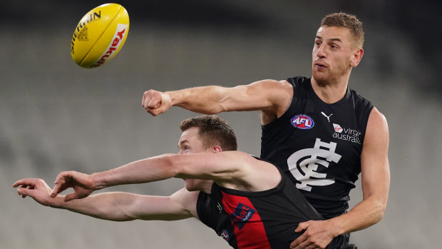 Pulling no punches: Carlton's Liam Jones clears ahead of Essendon's Jacob Townsend.