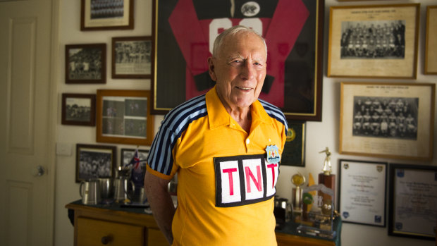 Noel Bissett wears his old referee uniform standing in front of his many awards that he has earned over the years. He has been inducted into the ACT Sport Hall of Fame as an associate member. 