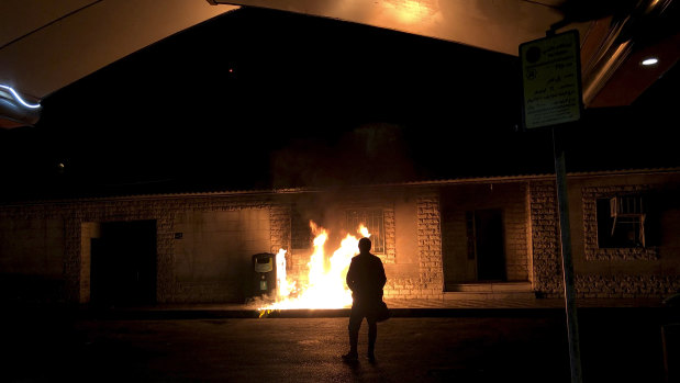 A man stands in front of a fire set amid demonstrations in Tehran, Iran, to remember victims of a Ukrainian airplane shot down by an Iranian missile.