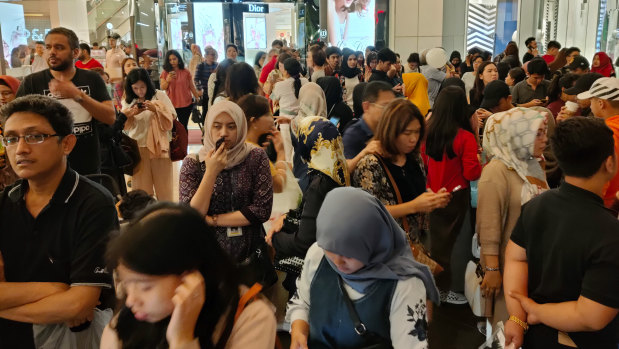 People stand outside a shopping mall following an earthquake in Jakarta.