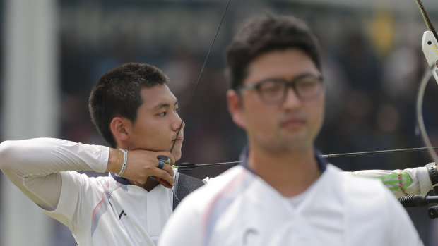 I'll go back and serve the country the best I can": Lee Woo-seok competes, as gold medallist Kim Woo-jin stands nearby.