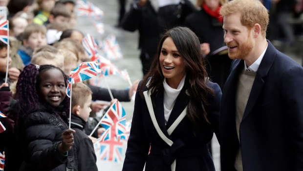 Prince Harry and his fiance Meghan Markle are greeted by flag-waving school children in Birmingham.