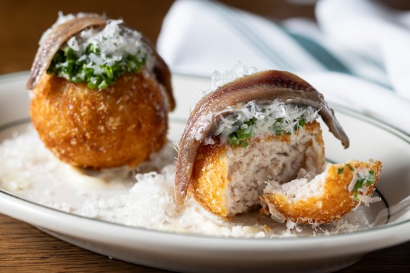 Chicken caesar croquettes draped with anchovy.