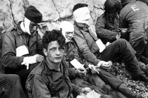 American assault troops of the 16th Infantry Regiment, injured while storming Omaha Beach, wait for evacuation to a field hospital in this photo taken at Collville-sur-Mer, Normandy, France, on June 6, 1944.  