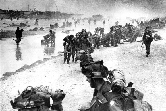 British troops move on the Normandy shore from their landing craft.