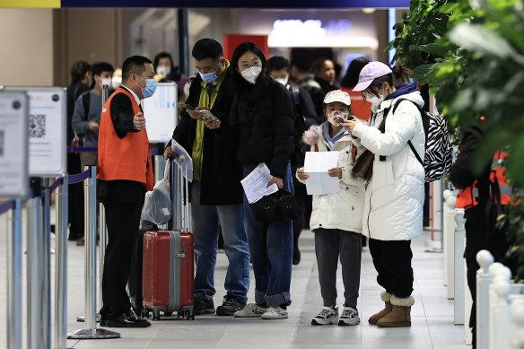 Passengers arriving from China this week wait in front of a COVID-19 testing area set at Charles de Gaulle airport. Australia will follow 10 other nations, including France, in screening passengers from China for COVID.