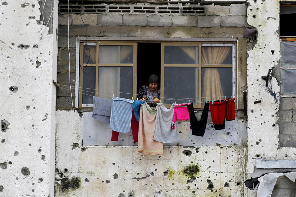 A Palestinian woman hangs clothes in an apartment block that was partially destroyed in Beit Lahiya in the Gaza Strip in 2014.