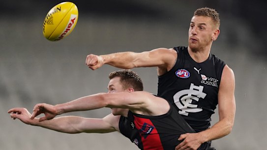 Pulling no punches: Carlton's Liam Jones clears ahead of Essendon's Jacob Townsend.