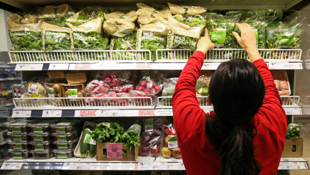 Workers re-stock shelves at Coles.