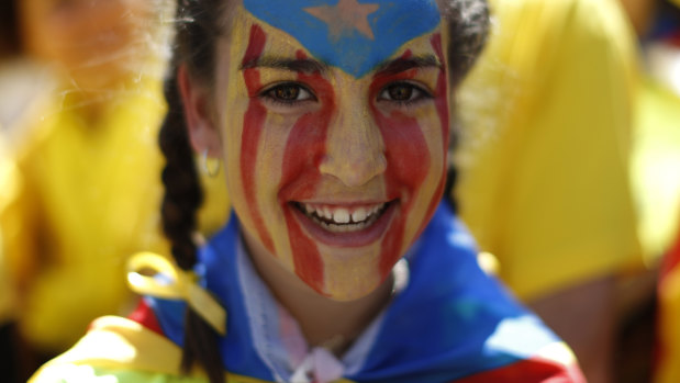 A protester with her face covered in the Catalan independence flag.
