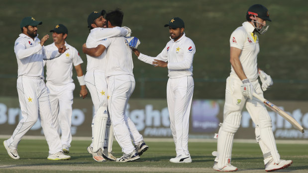 Bowled over: Pakistan celebrate taking the first wicket of Australia's second innings, after Shaun Marsh (right) was dismissed by Sarfaraz Ahmed (third left).