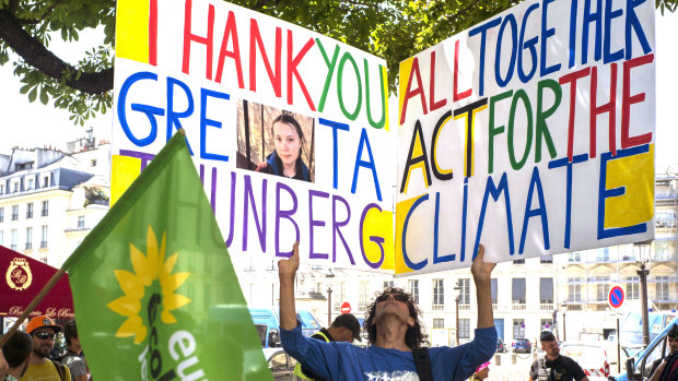 A climate activist holds a placard reading "Thank You Greta Thunberg " next to the French National Assembly during Greta Thunberg's visit to Paris last week.