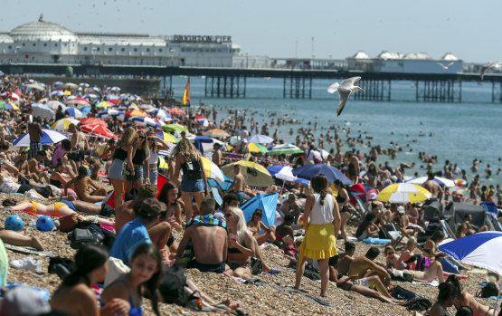 People crowd onto the beach at Brighton, England.