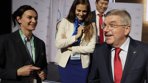 International Olympic Committee President Thomas Bach, right, and IOC member Yelena Isinbayeva, left, leave at the end of the 133rd IOC session in Buenos Aires.