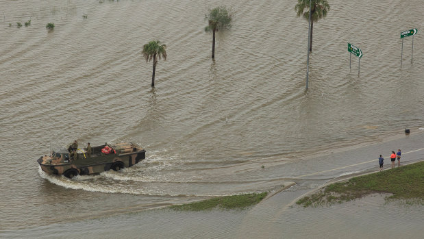 An army vehicle pushes through floodwater in Townsville.