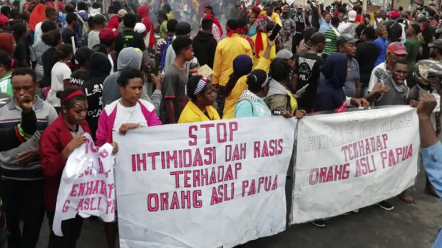 People display banners that read "Stop intimidation and racism towards indigenous Papuans" during a protest in Manokwari.