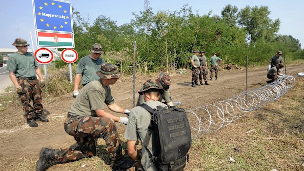 
Members of the Hungarian Defence Force erecting a border fence in 2015 to stem a wave of refugees.