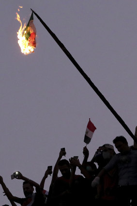 Iraqi Anti-government protesters burn the Iranian flag during a demonstration in Baghdad, Iraq.