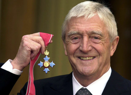 Chat show host Michael Parkinson poses for pictures after he was awarded an MBE in 2000. 
