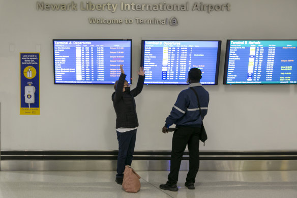 People check the boards as flights are delayed and cancelled at Newark Liberty International Airport.