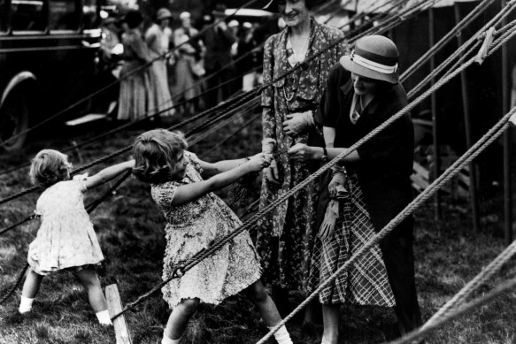 Princess Elizabeth and Princess Margaret playing with tent ropes at a fair in Scotland in 1933. 
