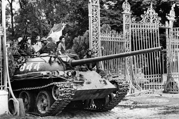 A tank rolls through the gates of the presidential palace in Saigon on April 30, 1975.